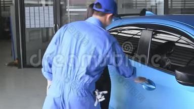 汽车修理工在汽车修理厂<strong>买</strong>车或维修后，把车钥匙交给女顾客驾驶。